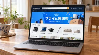 木の食卓に置かれたノートパソコンにプライム感謝祭の画面が表示されたイメージ