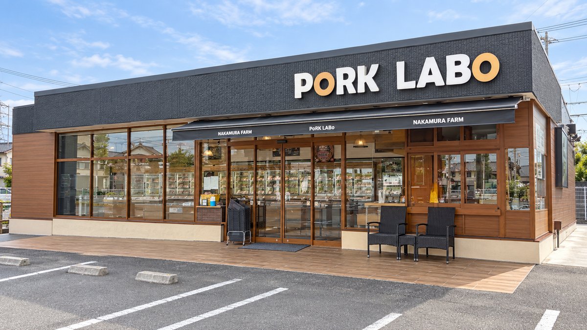 PORK LABOの看板と木目の外壁、ガラス張りの入口が見える店舗外観